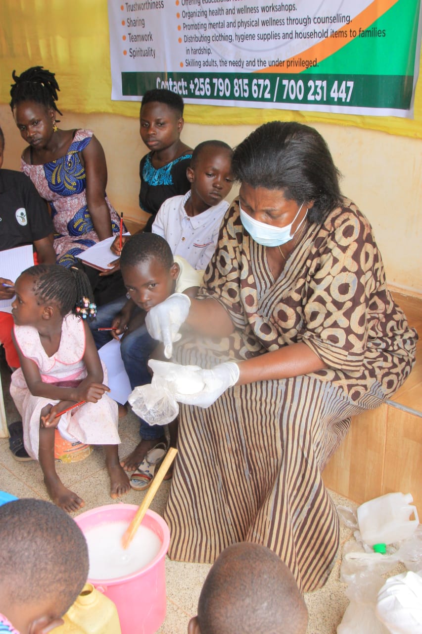 A trainer wearing gloves demonstrating soap making to a seated group