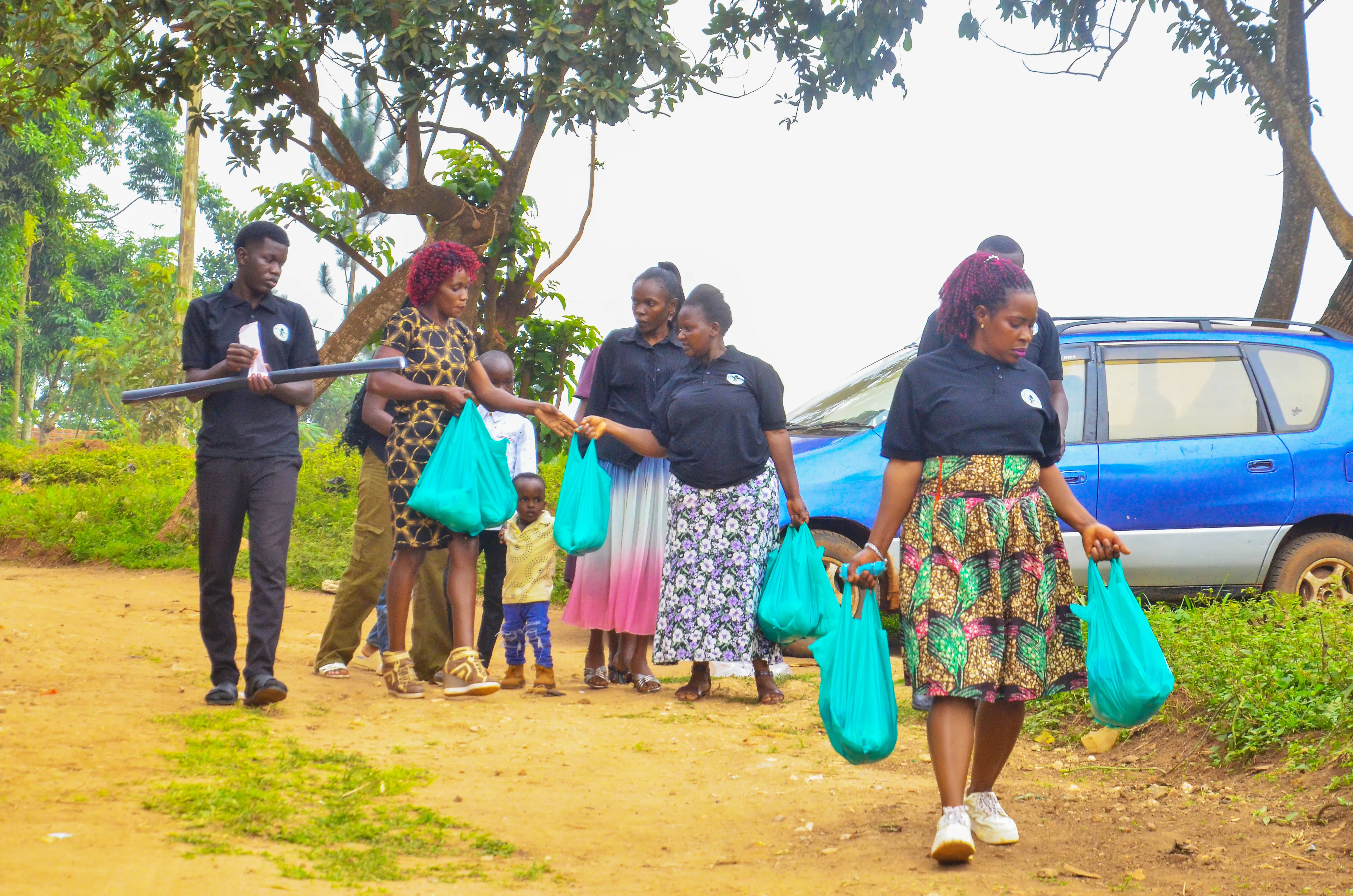 Foundation volunteers walking into a village carrying food parcels